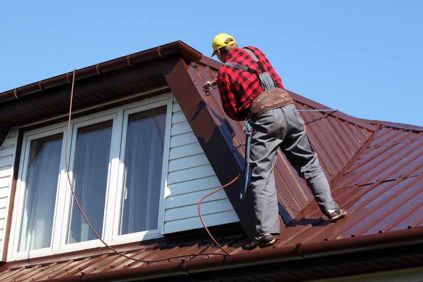 roofing contractor installing a metal roof